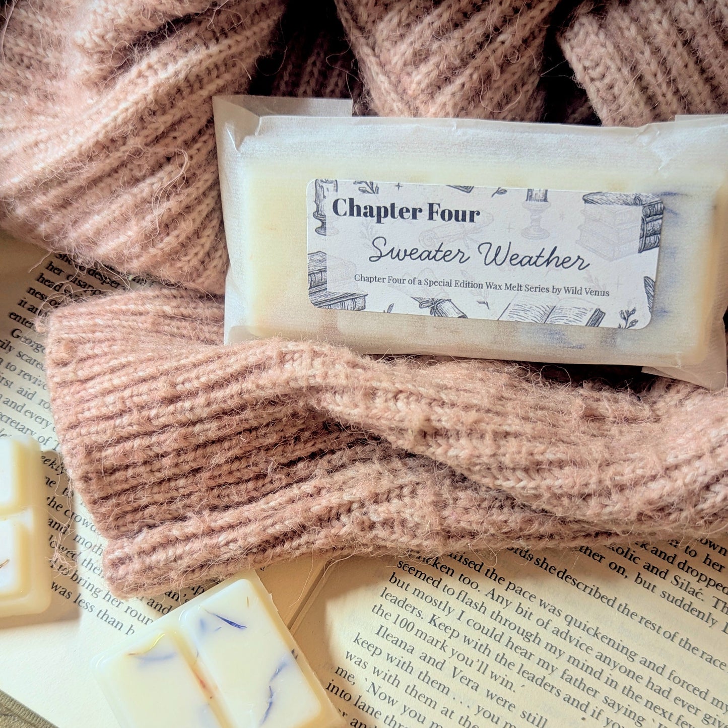 Wax melt with a label and knitted sweater, placed on an open book.