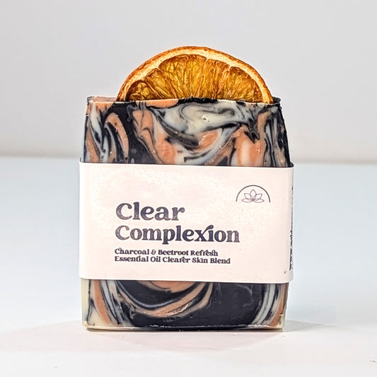 A single bar of the Clear Complexion soap with a label, is shown on a white surface and against a white background.