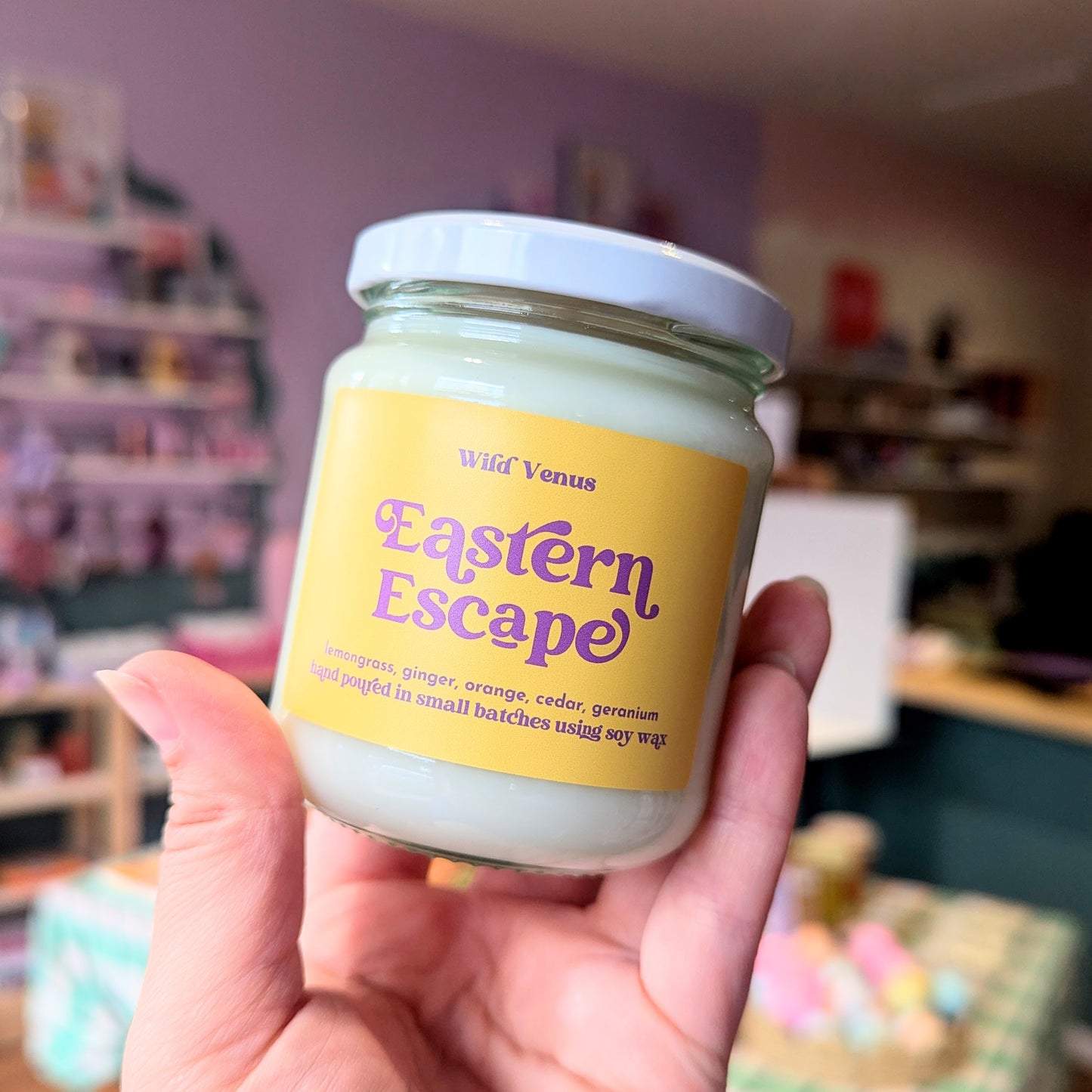 Holding the Eastern Escape candle fragranced with lemon, lemongrass and ginger.