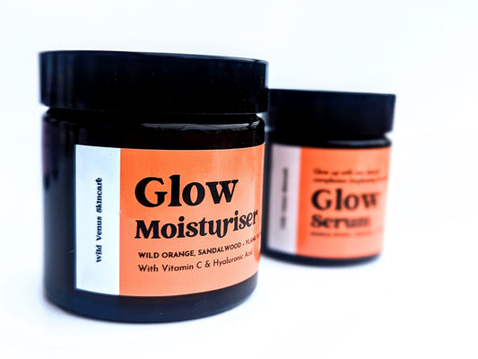 A Glow moisturiser in the forground and a glow serum behind, out of focus. The products are set against a white background.