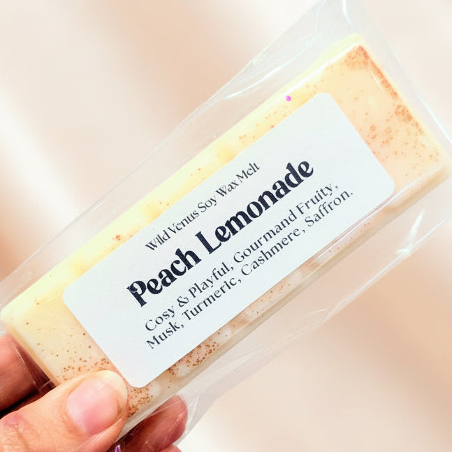Peach lemonade wax melt against a peach background.
