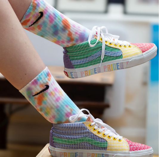 A model wears Snow Moon Creations colourful Nike socks in the Rainbow melt.