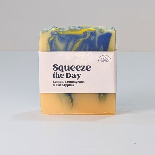 Lemon and lemongrass natural soap with a label which says in black lettering Squeeze the day.