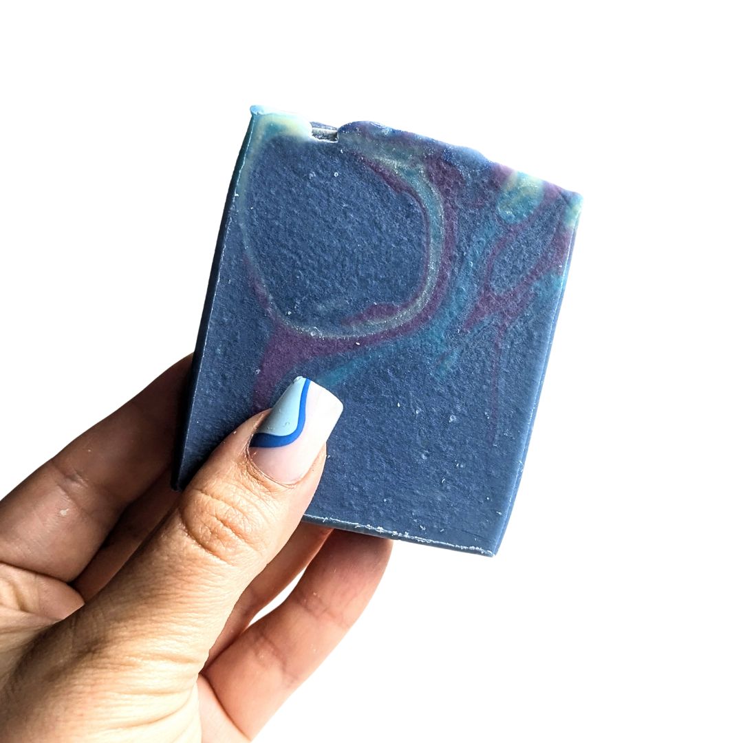 Holding a bar of Squeeze the Day vegan soap scented with essential oils. 