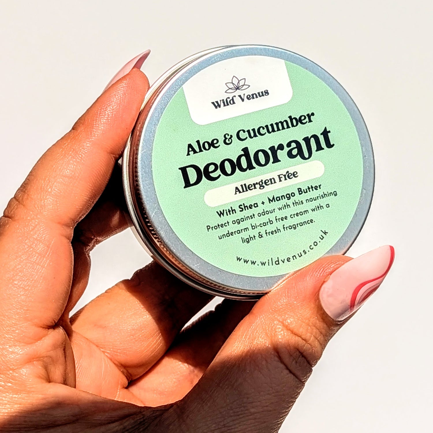 Holding the aloe and cucumber deodorant up.