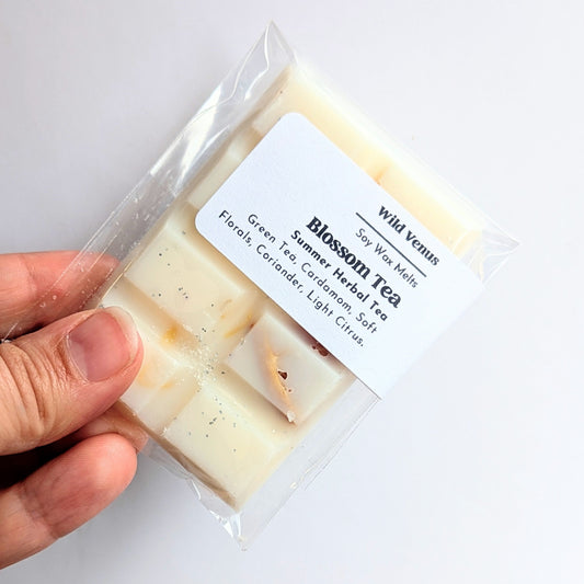 Holding a Soy wax melt Blossom tea in a package against a white background.