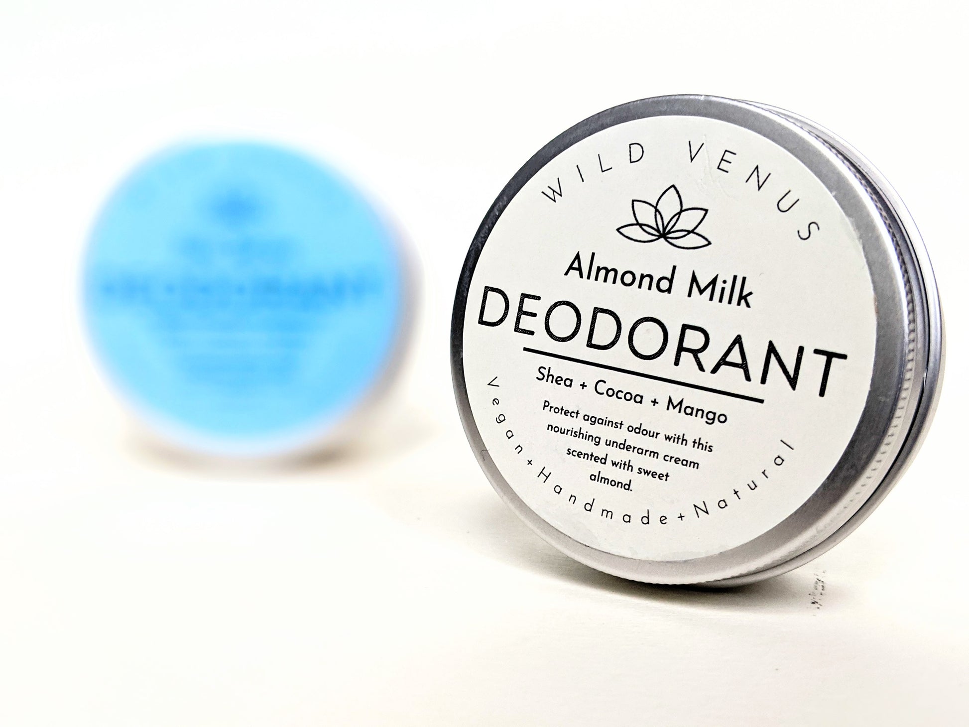 A tin of Almond Milk deodorant in front of the Sea Spray Deodorant. 