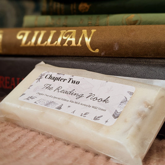 A close up image of the reading nook soy wax melt against some books. 