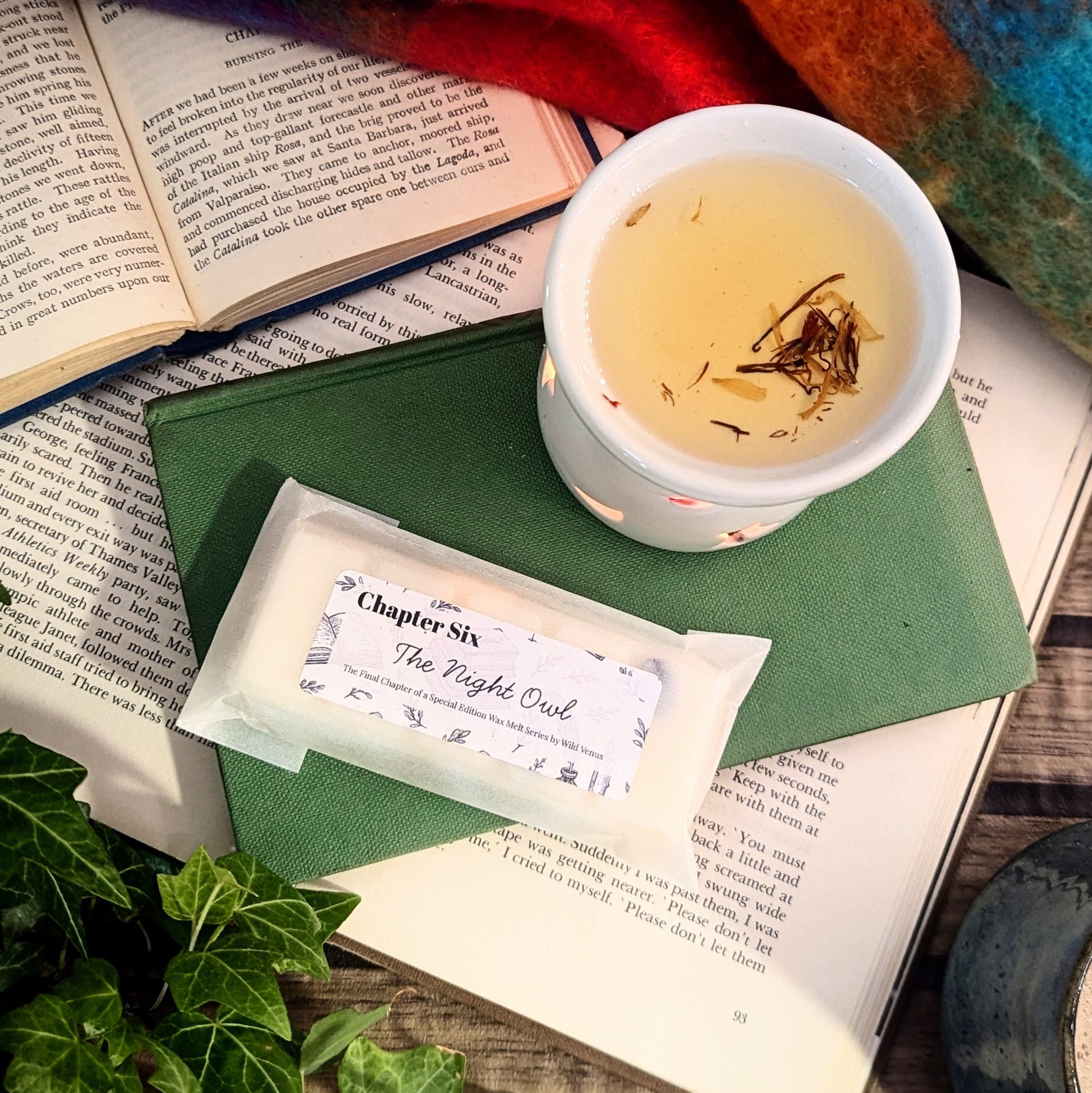 A wax warmer with a wax melt on top of books. 