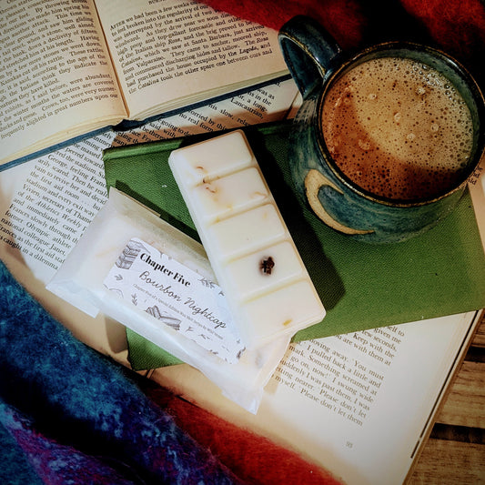 Open book with a mug of coffee, soy wax melts and a blanket