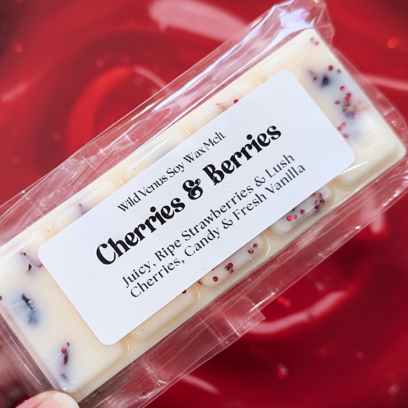 Cherries and berries wax melt against a red background. 