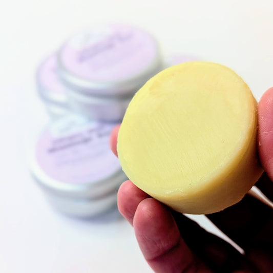 Holding a bar of the dreamy skin massage bar.