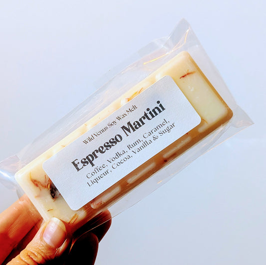 Hand holding a wax melt bar with espresso martini scent against a white background. 