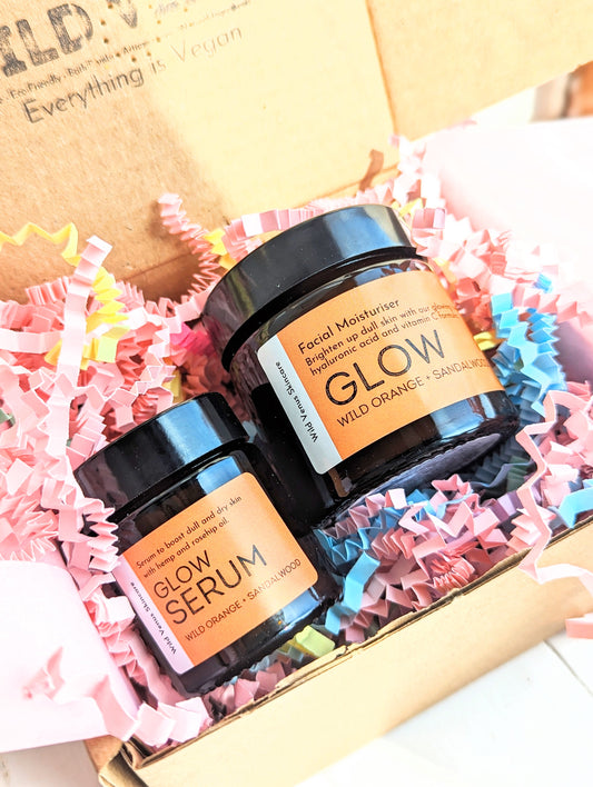 The Glow Serum and Moisturiser shown in a box packaged with colourful shredded paper. 