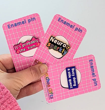 Holding a bundle of 3 Katchee Gifts enamel pins