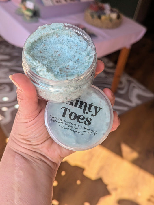 Holding a jar of Minty Toes salt scrub.