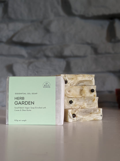 A bar of wrapped herb garden soap in front of a stack of 4 bars of herb garden soap. 
