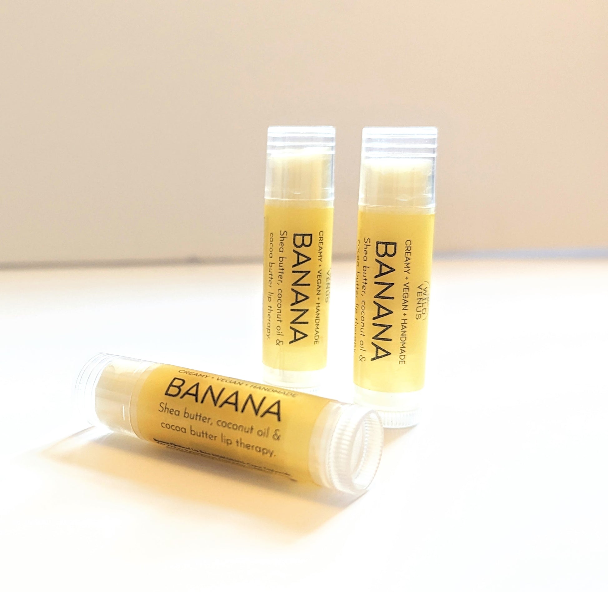 Three tubes of Banana flavoured Lip Balm against a white background. 