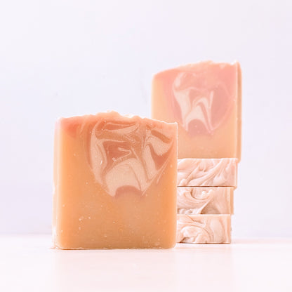 Five peach scented soaps against a white background. 