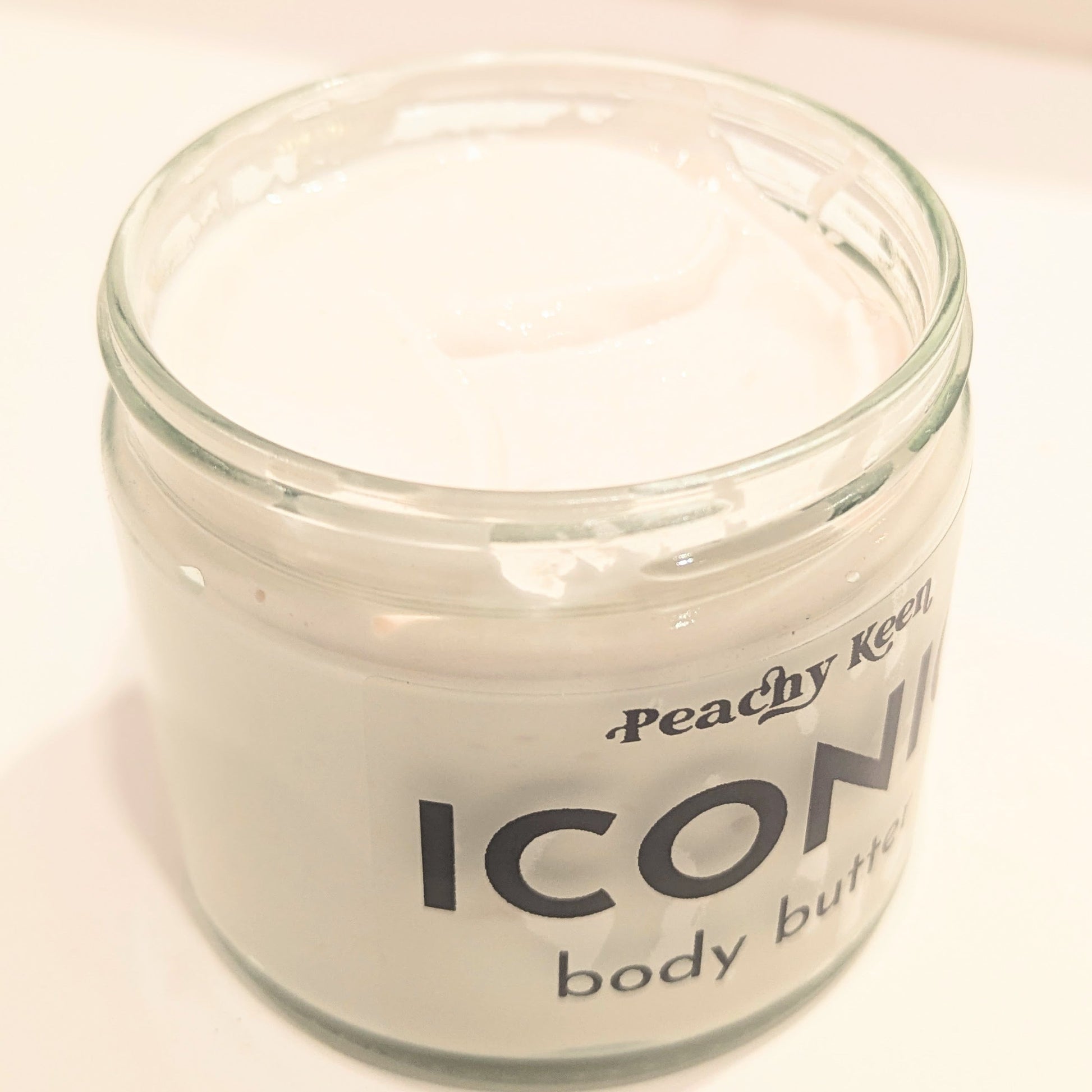 Glass jar of Peachy Keen Icon body butter on a white background