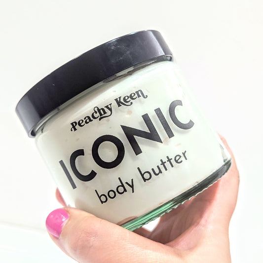 Hand holds the Peachy keen iconic body butter.