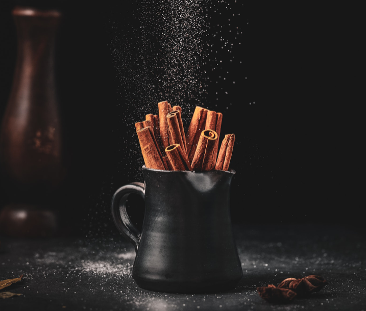 A bunch of cinnamon sticks in a sleek black jug.