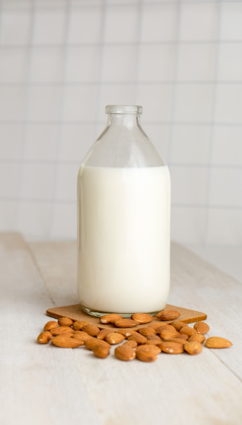 Photo of a bottle of milk and some almonds. Photo taken by Sandi Benedicta