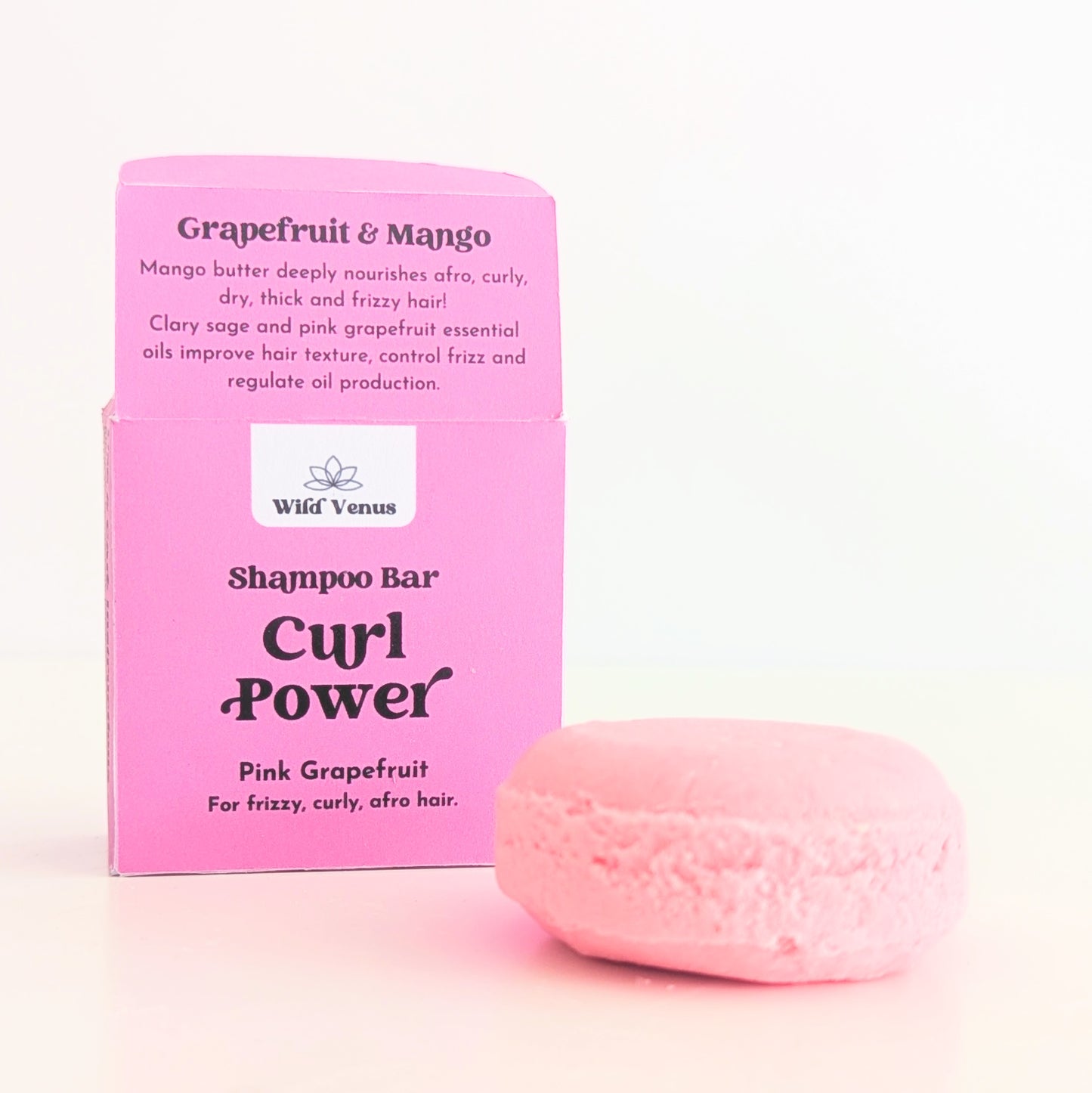 An open box of Curl Power hair shampoo bar. A pink shampoo bar is in front of the box.