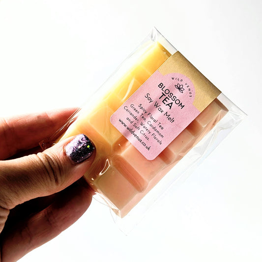 holding a Soy wax melt Blossom tea in a package against a white background. 