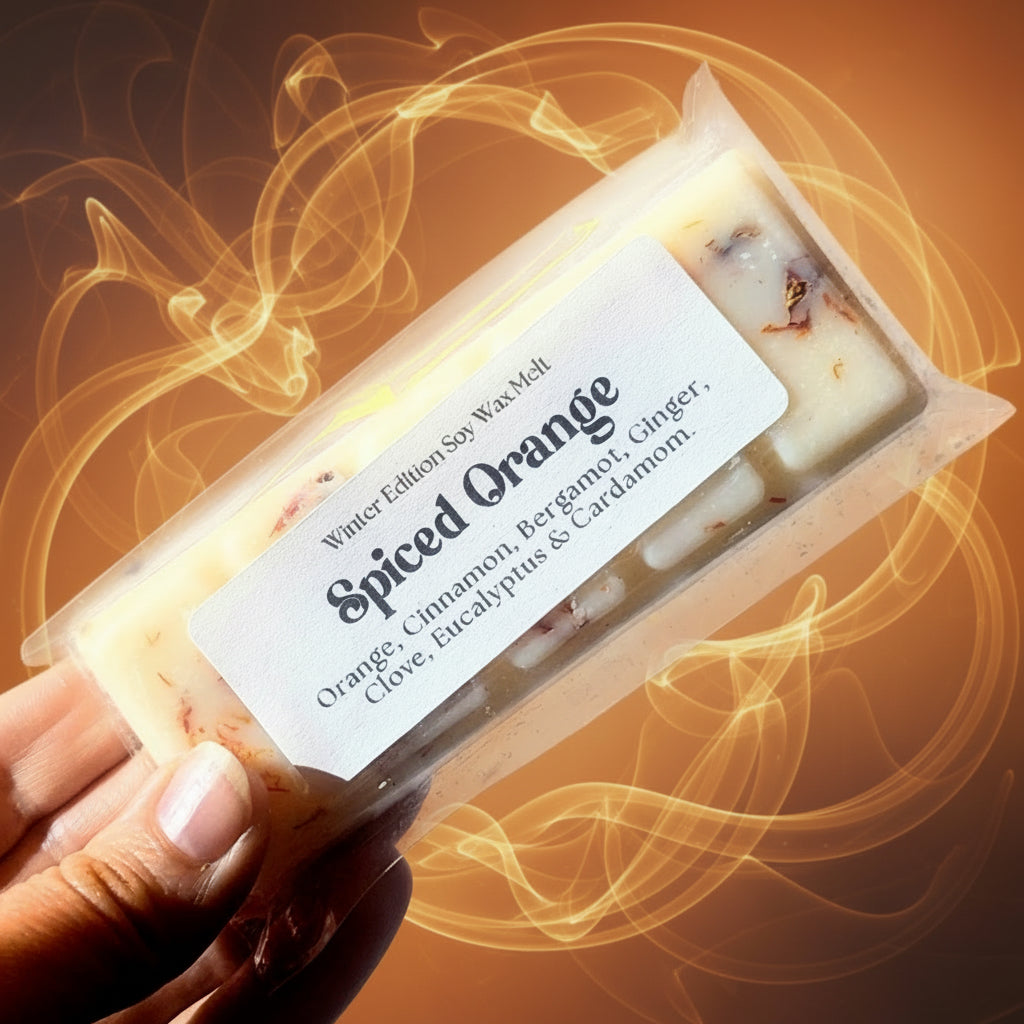 A hand holds the spiced orange soy wax melt against a white background.