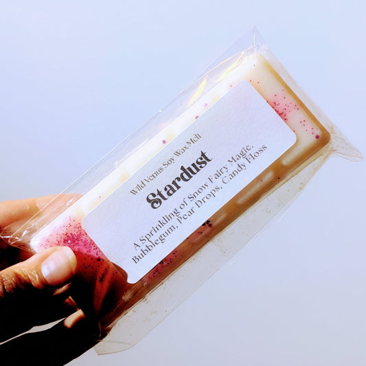 Holding the stardust soy wax melt against a white background.