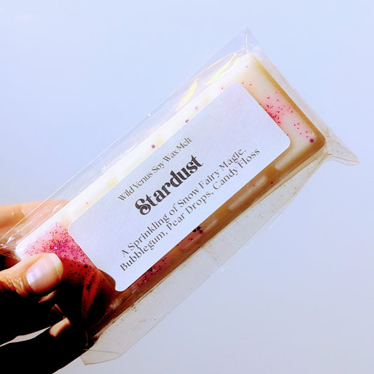 Holding the stardust soy wax melt against a white background.
