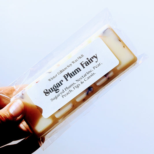 A hand holds the Sugar Plum Fairy soy wax melt against a white background.