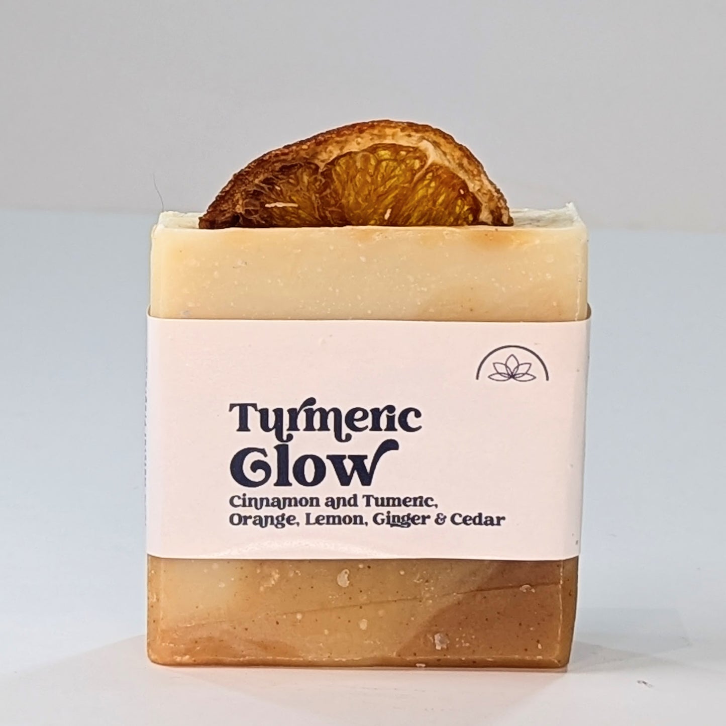 A bar of handmade Turmeric Glow vegan soap with orange, lemon, cedar wood and ginger essential oils. 