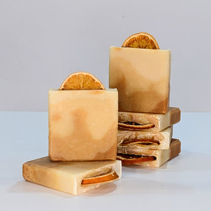 Several bars of turmeric glow vegan soap palm oil free soap are stacked on top of each other in 2 stacks.