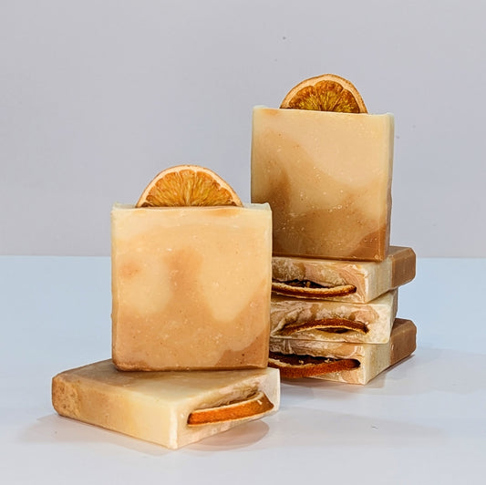 Several bars of turmeric glow vegan soap palm oil free soap are stacked on top of each other in 2 stacks.