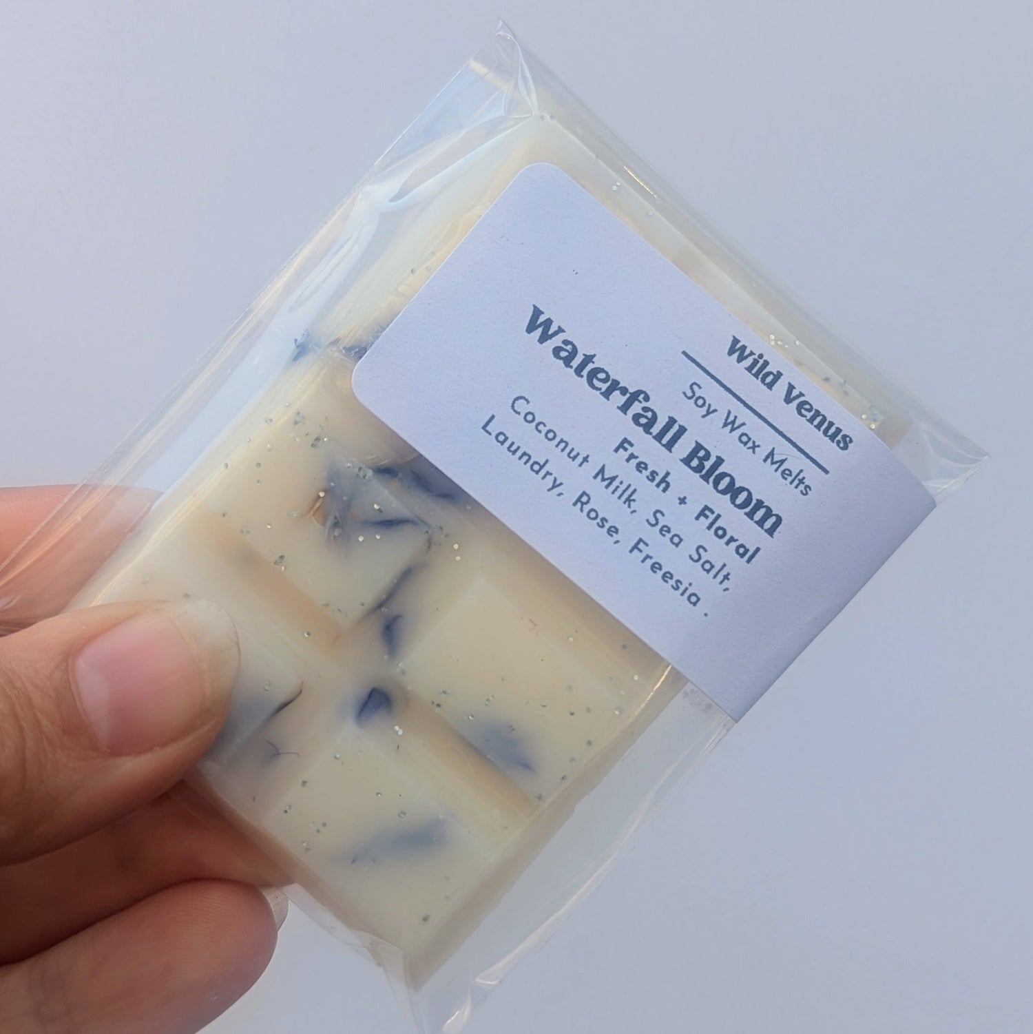 Holding a Soy wax melt Blue Lagoon against a white background.