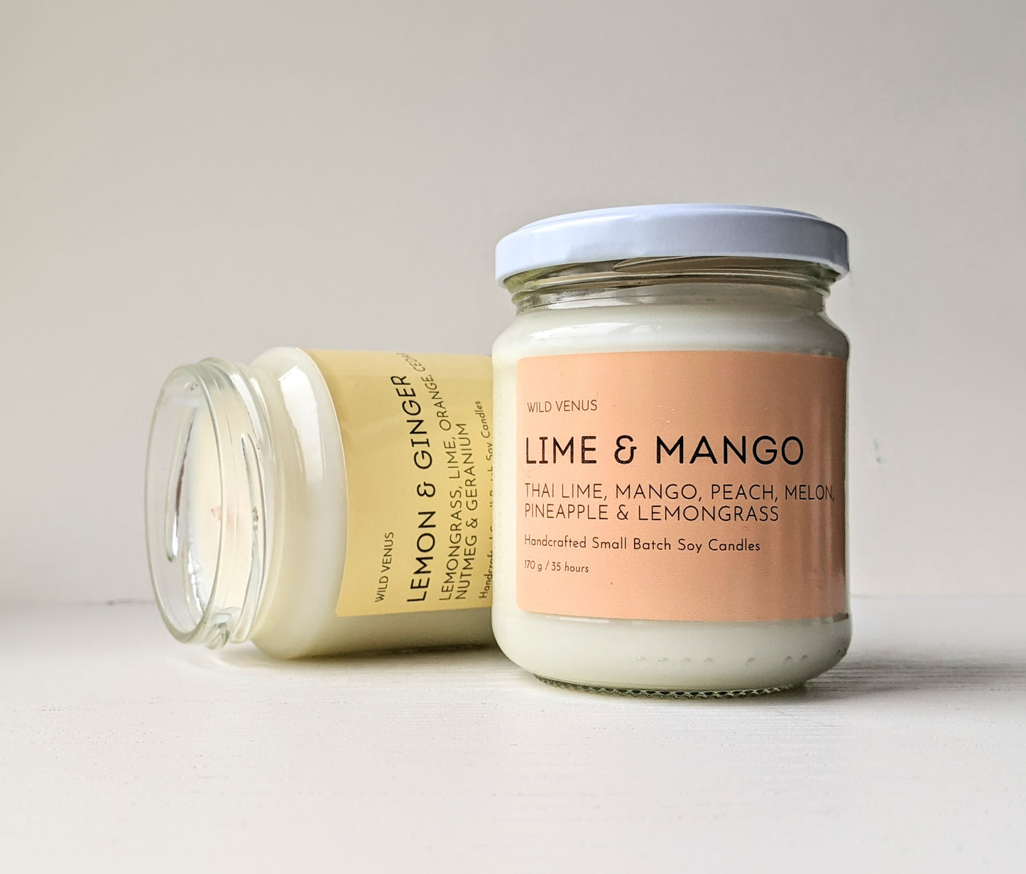 A Lime and Mango and a Lemon and Ginger scented hand poured soy candle against a white background. 