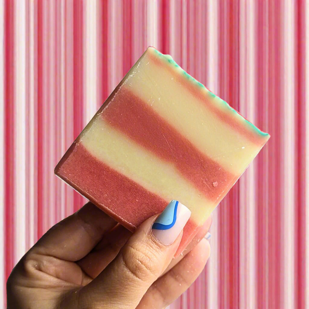 a candy cane soap against a striped red and white background.