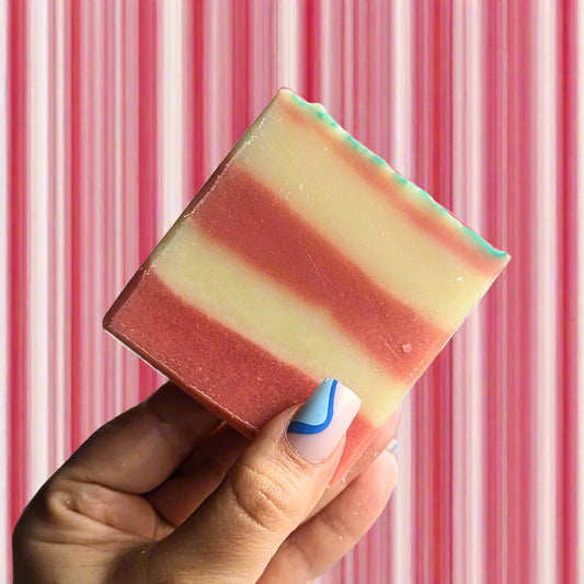 a candy cane soap against a striped red and white background.