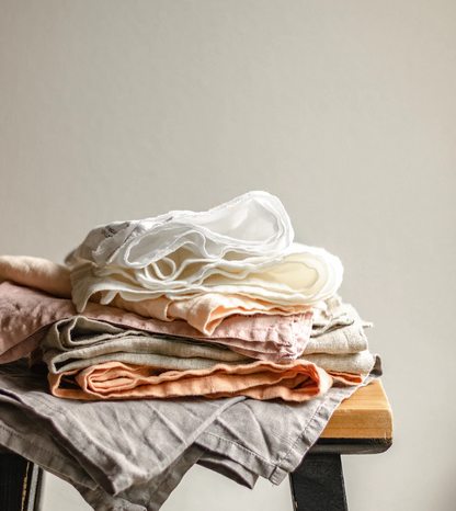 A pile of clean linens folded on a stool.